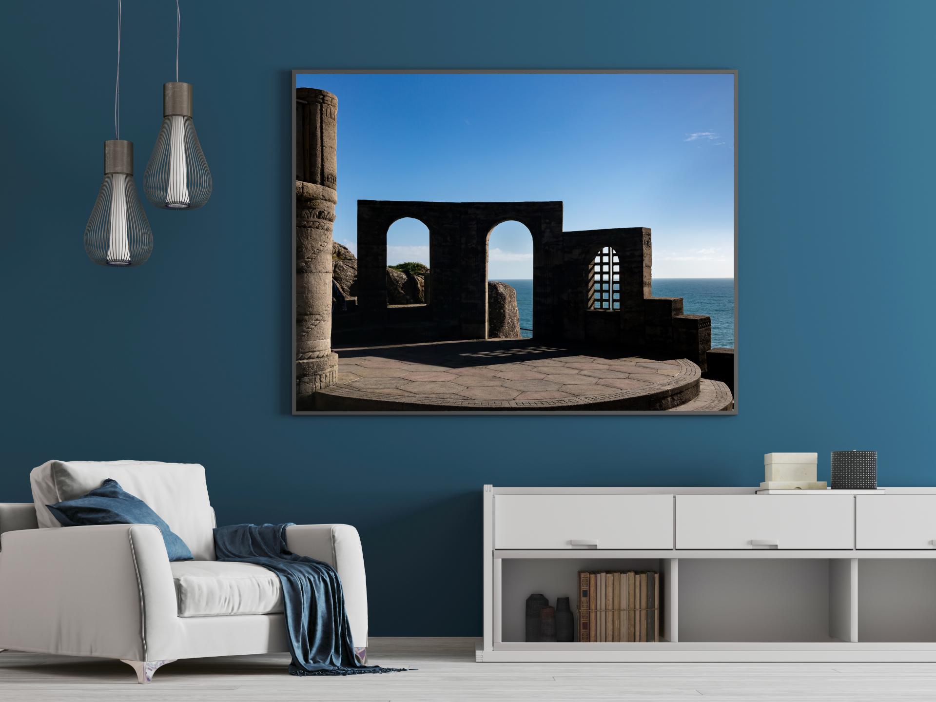 Looking out from the Minack Theatre through a stone archway out to the sea with blue skies. Liane Ryan Photography