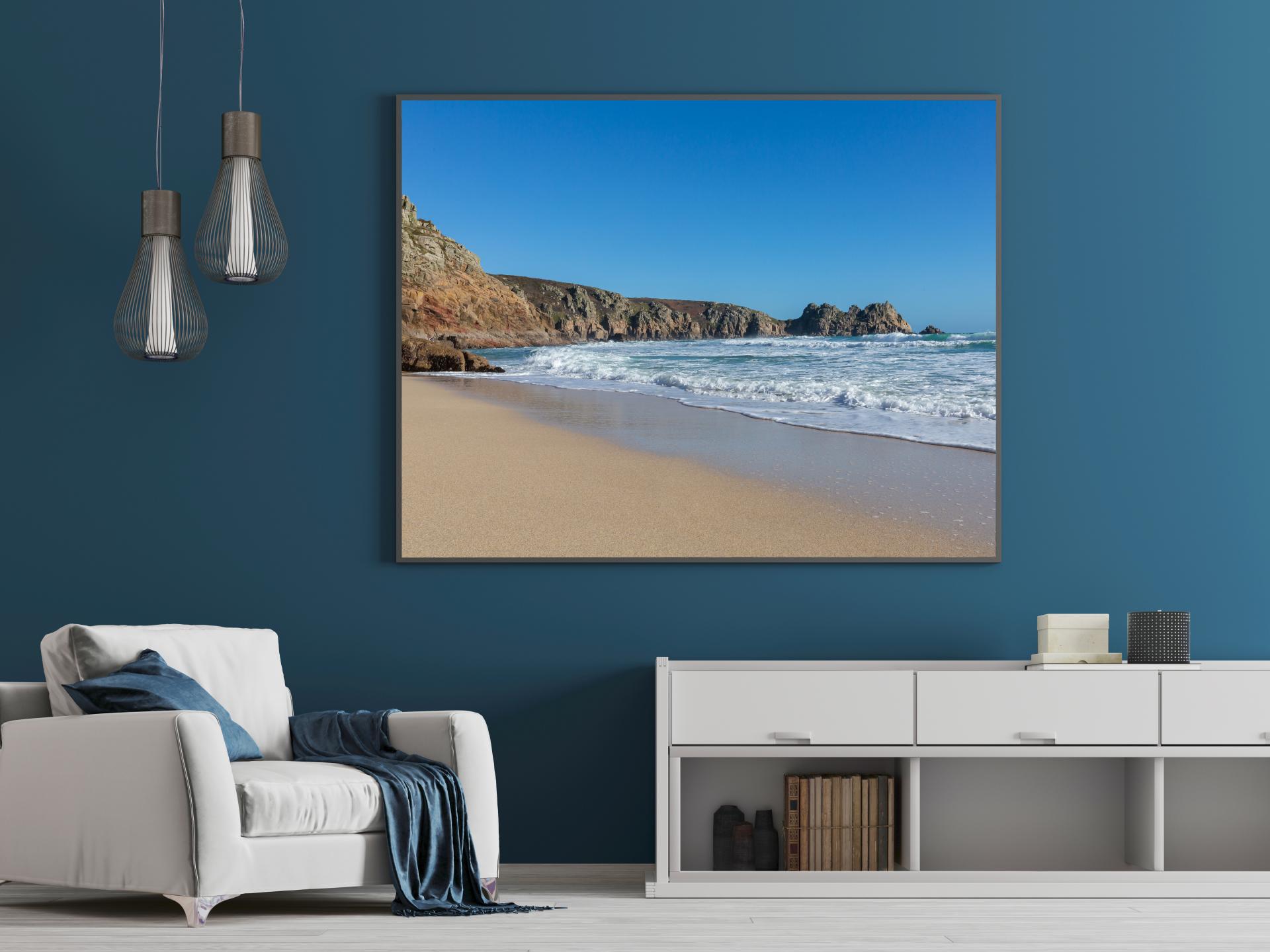 Waters edge at Porthcurno Beach, cornwall, with cliffs to the left curling around the image. Liane Ryan Photography