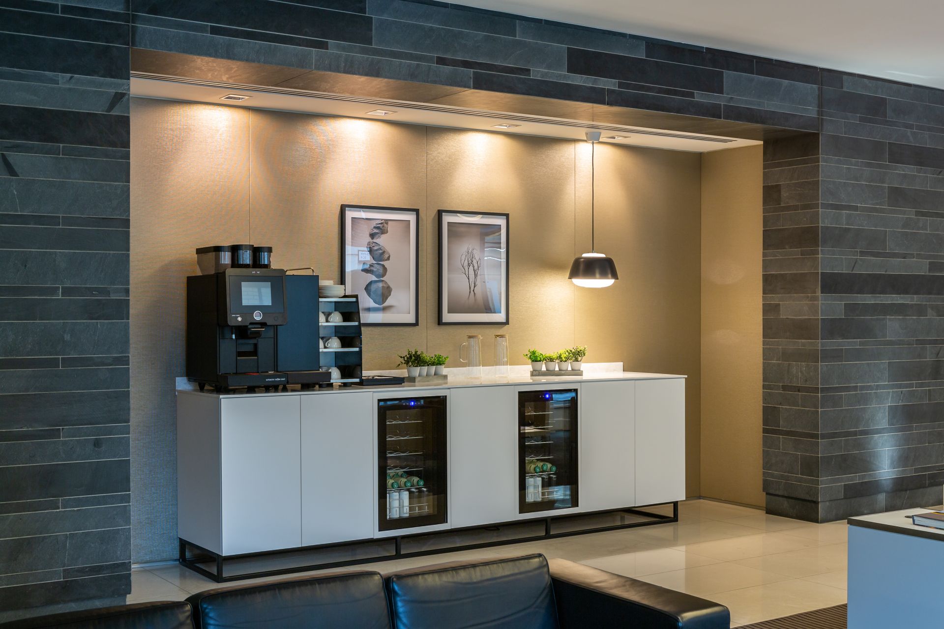tea point in office showing two fridges under a counter with coffee machine