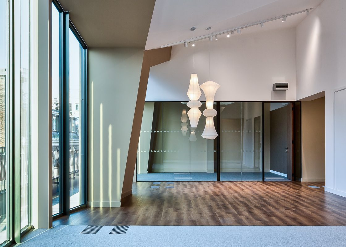 Interior office photography showing interior of unusual ffice space with high ceilings and creative ceiling geometry