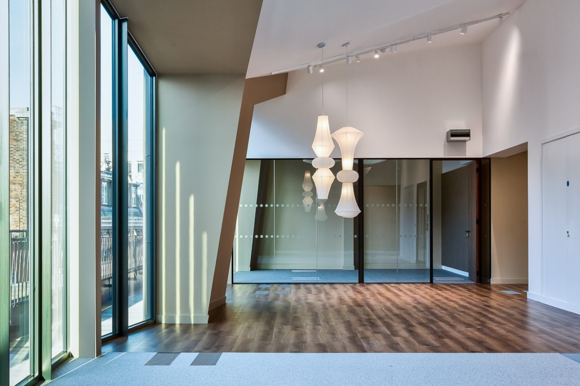 Interior office photography showing interior of unusual ffice space with high ceilings and creative ceiling geometry